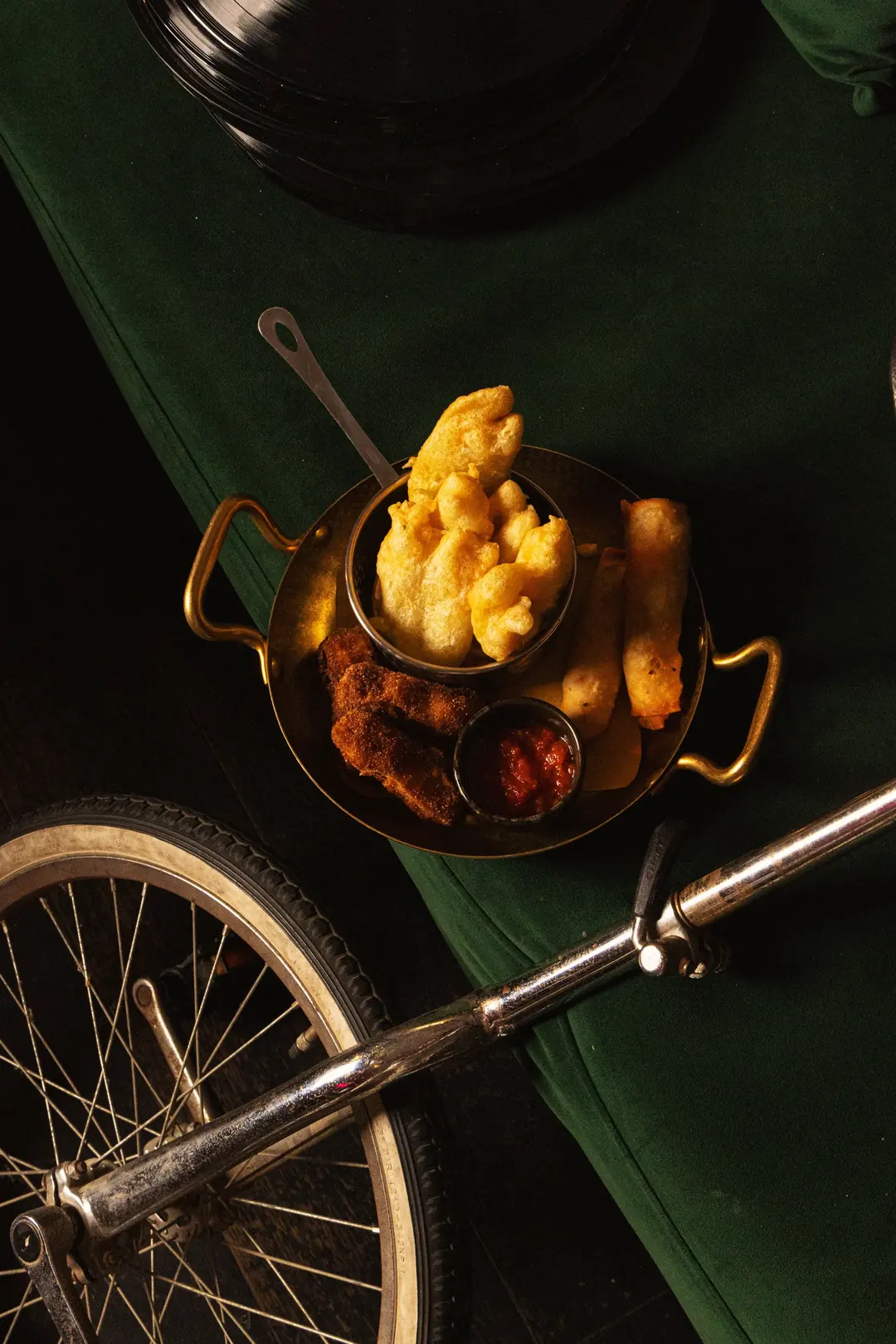 Fritto servito in una padella di rame accanto a una bicicletta